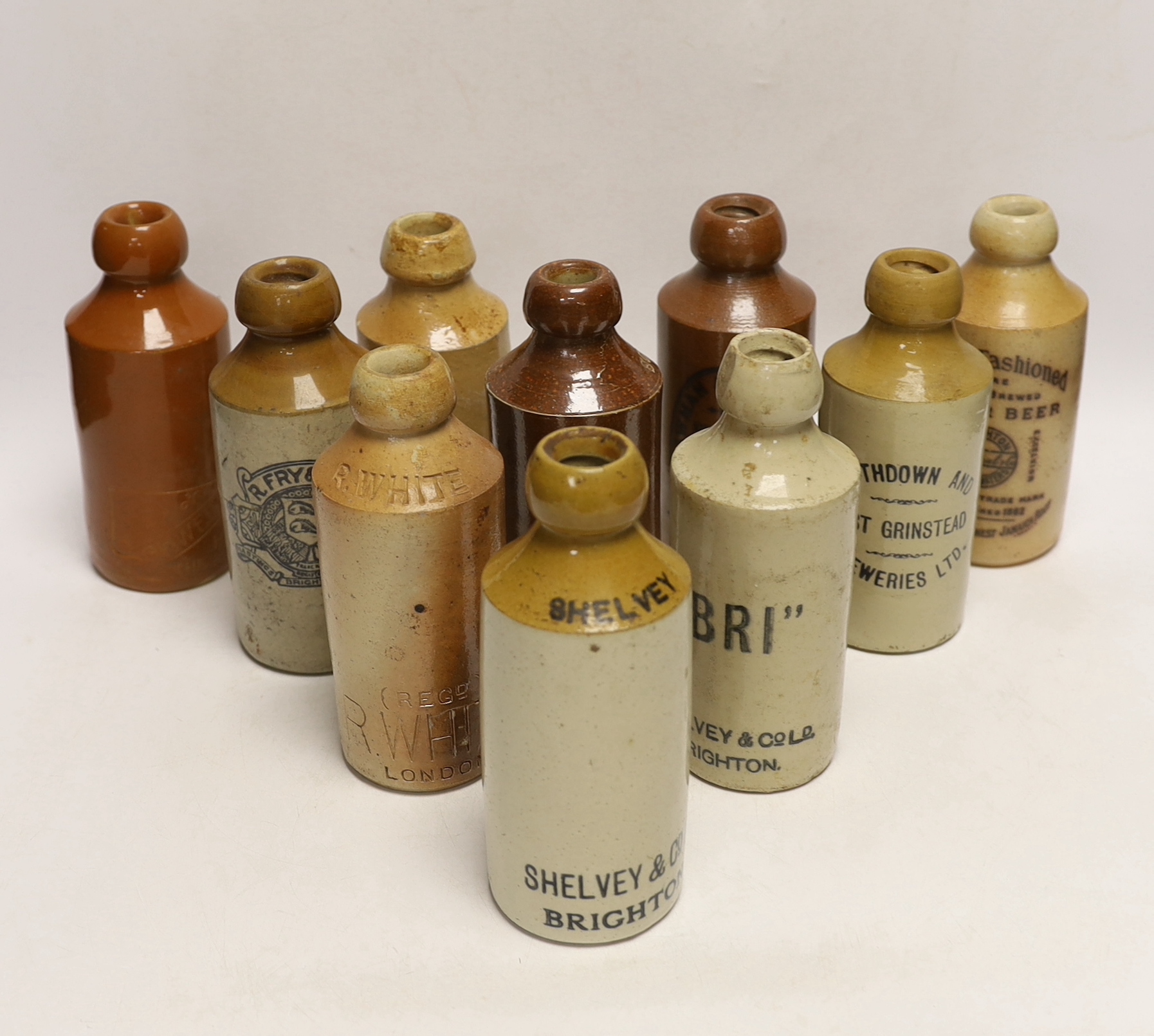 Early 20th century stoneware ginger beer bottles, two of Brighton, one of London, one of East Grinstead and four others